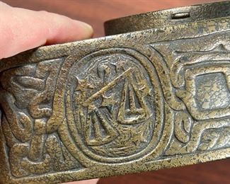 TIFFANY ZODIAC CLOCK  |  
Tiffany Studios New York desk clock with an arched bronze case, having zodiac designs replete with matching key in fitted holder on caseback door. - l. 4 1/4 x w. 2 x h. 5 1/4 in. (overall)