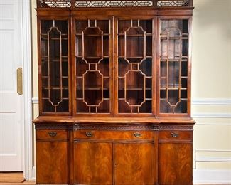 CHARAK BREAKFRONT CABINET  |  
Carved scalloped open work gallery for glazed cabinet doors over a serpentine front lower section with fitted silver drawer to side drawers over for cabinet doors, blind fretwork, leaf pattern carving, with label dated 1936 - l. 64 x w. 20 x h. 78 in.

Condition: One area of lifting veneer secured with scotch tape one cracked glass panel piece of trim not attached, but present otherwise appears in very good condition
