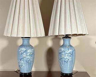 (2pc) PAIR BLUE PORCELAIN LAMPS  |
A pair of blue porcelain table lamps with textured floral decoration mounted on wood stands with scalloped shades; vase only h. 16 in. - h. 37 x dia. 18 in. (overall with shade)
