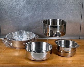 (4pc) CUISINART STEAMER INSERTS  |
Stainless steel steaming pot inserts, one brand new in plastic wrap, all marked on the bottom - dia. 10.75 in. (largest)