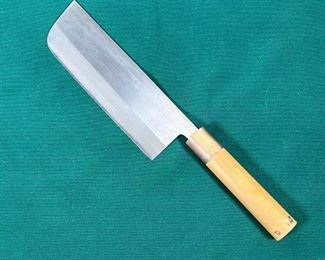 JAPANESE CHEFS KNIFE  |
6.75 inch blade with incised markings, having a wood and horn handle call mom with remnants of label at bottom of handle - l. 12 in. (Overall)
