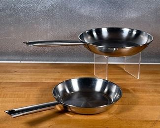 (2pc) STAINLESS FRYING PANS  |
Stainless steel cookware, including a small Cuisinart frying pan (dia. 8.25 in.) and a larger unmarked frying pan (dia. 10.25 in.)
