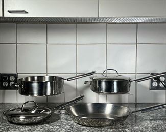 (4pc) CUISINART COOKWARE  |
Including a 10 inch frying pan, a 10.75 inch deep pan, a 10 inch low pot, and a 13 inch frying pan, with three lids, two of the pans marked on the handles, the other two with no markings but with the same handles
