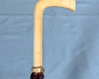 BONE HANDLE CANE  |
Wooden cane having a curved bone handle intricately carved with belt motif and a seal monogram - h. 34-1/2 in.