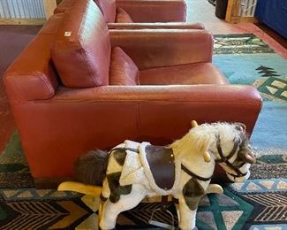 Vintage rocking horse and cool orange leather chairs. Very comfortable 