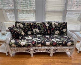 Wicker couch has matching end tables and coffee table.