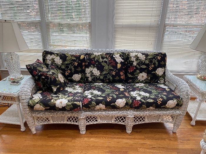 Wicker couch has matching end tables and coffee table.