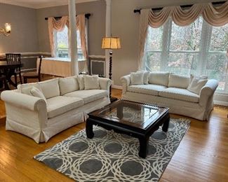 Drexel white upholstered slip-covered sofas & Gordon's square glass coffee table