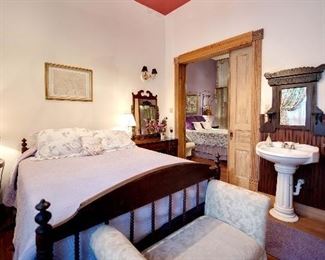 Jenny Lind style Jahn bed made from local walnut, adapted for queen sized memory foam mattress, mattress included. Some damage at the headboard which can be mended. Dressing table with mirror, mirror over sink, bench at foot of bed, corner table.  