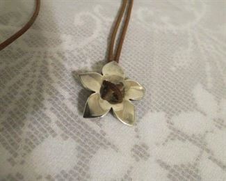 James Avery hibius flower pendant on leather rope.