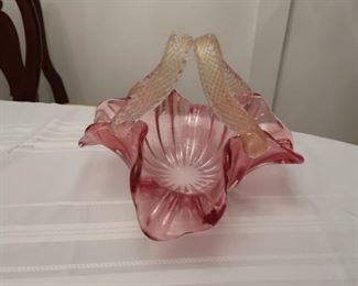 114    Cranberry glass  bowl with  handles.   the  handles  appear  to  be venetian  glass (has  gold  specks  throughout)  It  is  12  1/2"         95.00