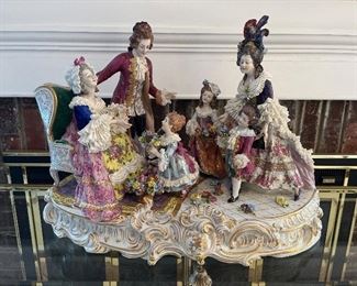 Living Room:  A very detailed Dresden porcelain piece titled "Grandma's Birthday" measures approximately 22" wide x 12" deep x 15" tall.  Its nearby Lucite cover is included in the price. 