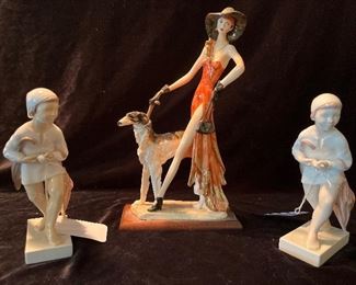 Living Room:  Two B&G porcelain figures showing  girls holding umbrellas flank a signed "A. SANTINI" figure of a tall  woman and a Borzoi dog.