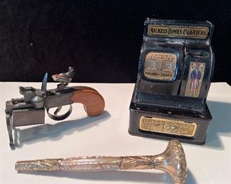 Living Room:  More collectibles:  a circa 1930 DUNHILL Tinder Pistol cigarette lighter and a vintage Uncle Sam cash register are near a Mother-of-Pearl/gold- filled umbrella handle.