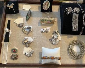 Living Room:  The case contains sterling jewelry; Italian micro-mosaic pins; a colorful rhinestone Judith Lieber lipstick case; a long, narrow lacquer pin; a porcelain portrait pin; and a beautiful carnelian / cloisonne bracelet.