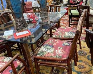 Gorgeous rattan dining table, four side chairs and two armchairs with floral fabric covered pop out cushions. 