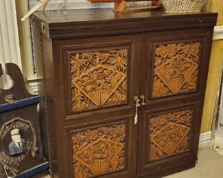 large bar cabinet with carved wood panels from southeast Asia
