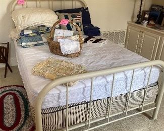 Antique full size iron bed with mattress, linens, hand made wall hanging