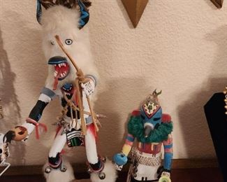 Kewanwytewa and Arthur Smith Kachina Dolls.  One on left is by Arthur Smith. This beautiful Kachina doll by renowned Kachina maker Arthur Smith (one of his dolls sold for $21,000) stands 16” tall with the base. This is in mint condition. The laugh-worn eyes of Arthur B. Smith hide a courageous yet triumphant story. Not only did he face the dangers of the 1942 Bataan Death March and three years in a Japanese prisoner of war camp, he went on to lead a productive and fulfilling life. Smith was born June 14, 1919, to José Padilla Smith and Isabel Britton Smith in Santa Fe, N.M. Neither of his parents received more than a third-grade education. One of eight brothers and sisters who grew up in Santa Fe, Smith graduated from high school and joined the military in 1940. Upon leaving the military, Smith began working as a manager at Sears & Roebuck Inc. He held that position for 28 years, until he retired in 1980. He also began the hobby of carving out of wood Native American kachina dolls, eac