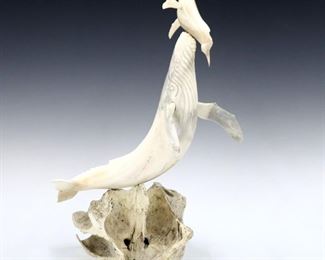 A contemporary Inuit Bone carving depicting a Whale with calf.  Polished finish with incised detail on an ossified Bone fragment base.  Signed "Mark" (n.d.) at tail.  Crack to bone along whale body.  Approx. 10 x 9 x 14" high overall.  ESTIMATE $400-600
