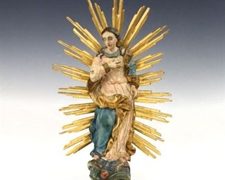 A 19th century Spanish Colonial carved wood Santos figure.  Depicts The Madonna above the serpent and forbidden fruit surrounded by radiant light, with polychrome decoration and Gilded detail.  Some wear and minor damage, glued repairs.  13 1/2" high.  ESTIMATE $300-500
