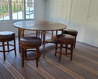 Large unusual country gateleg table. Four low leather top stools
