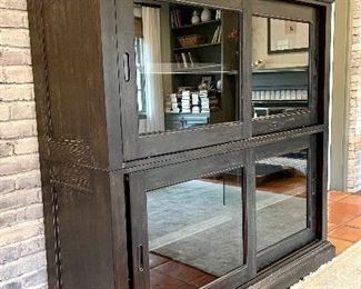 SOLD - Distressed black cabinet by Bassett Furniture. Two pieces, both with center shelf, sliding doors. Unit offers electrical access on both the top and bottom. 64L x 21W x 63H. Excellent condtion. 