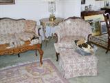 Carved French stylked sofa with matching carved chair. The chair has an ottoman.