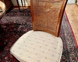 10 caned upholstered chairs with dining table and 2 leaves.