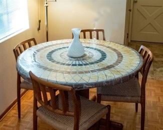 Skovby Round wooden teak table has 2 leaves.   Table is shown with a cover.