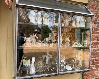 Three bays of green house windows filled with angels