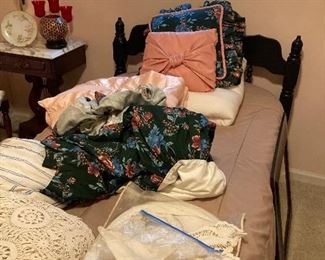 Twin bed with only some of piles of linens