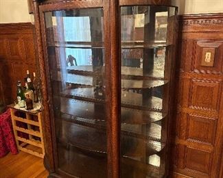 Antique tiger oak bowed China cabinet early 1900s with Chinese dragon embellishment and claw feet