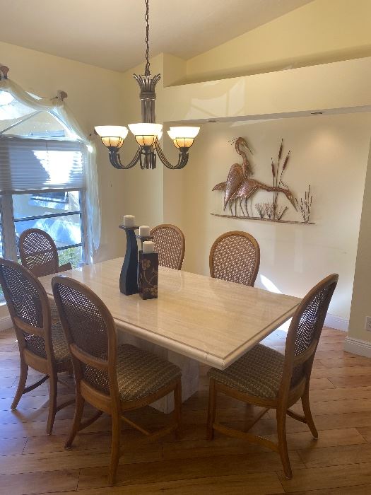 Stone International USA Travertine dining table purchased at Rob and Stucky 71" X 42"and 6 wood and cane back chairs. Heron metal wall art 40" x 33"