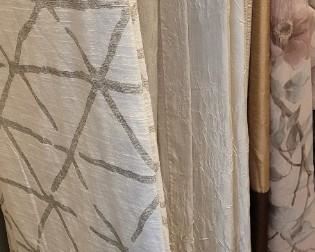 several sets of drapes, most with grommets for hanging