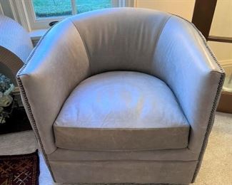 Grey leather barrel back swivel chair with side tufting