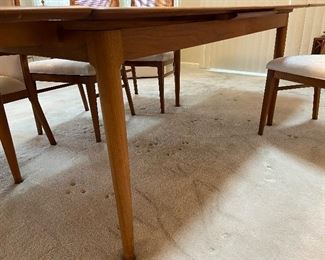 Mid Century Danish Skovmand & Andersen Teak Draw Leaf Dining Table, c.1960s.  Comes with 6 cane and upholstered chairs, 2 arm chairs, 4 armless. Both leaves slide underneath converting the table to a smaller size. Approx. size with both leaves: 8'6l x 3'1w x 2'4h