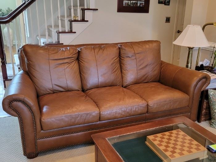 There are two of these brown leather sofas