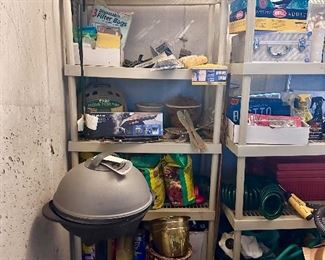 A couple shelves in garage filled with random stuff.