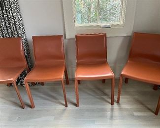 There are eight of these magnificent leather orange saddle chairs.