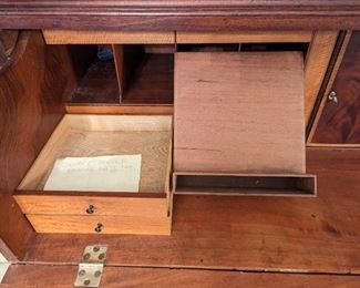 What you're seeing here is a secret drawer, located behind two of the pull out drawers to the left of the central desk door.