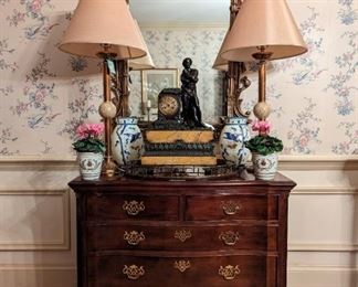 Vintage Chinese Chippendale Georgian-style mahogany 5-drawer chest, by Henredon, antique French bronze/marble mantle clock, vintage gold wall mirror, pair of antique brass candlesticks, w/polished granite spheres and dimmer switch (more creations by Paul Smith, local ATL lamp Legend) pair of hand-painted L-R facing antique milk glass vases, pair of white/gold porcelain cachepots, with fresh cyclamens, vintage mahogany serving tray with brass gallery.