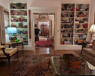 View of the living room, looking out into the foyer. There are three bookshelves absolutely crammed with very good, collectible smalls.