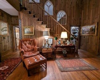 Oh-so-comfy wood paneled den, with vintage leather wingback chair and matching ottoman, by Classic Leather Inc. (Hickory, NC), vintage leather-topped side table, with two drawers and drop-down leather writing surface, by Globe Furniture Co., (Evansville, IN) amazing antique "Hinks" English silverplated banquet lamp, with shade and crystal finial, original oil on board of Catholic church in Ramsau bei Berchtesgaden, Germany, by L. Schöne, 1963, vintage hand-woven Persian Herati rug, measuring 3' x 5' 1980's mahogany console table, with vintage brass table lamp, assorted Asian porcelains, with porcelain Asian jar on wooden stand, underneath.