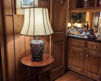 Asian earthenware table lamp on vintage mahogany candlestick table.