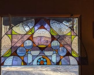 Art deco-inspired stained glass arc, in metal frame.