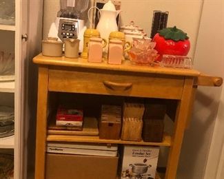 Rolling cart contents sold separately: Montell Williams Vitamix style Blender, Coffee Carafe, Ceramic Canisters, Ceramic Cup and Saucer Set, Ceramic Cream and Sugar Set, 2 Sets of Ceramic Salt and Pepper Shakers, Lucite/Plastic Napkin Holder, Strawberry Cookie Jar, Glass Butter Dish, Jar Lid Openers, Cutting Board, Knife Blocks, Food Saver, Fondue Set.