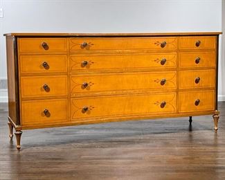 SCHMEIG & KOTZIAN LONG DRESSER  |                                       Tiger maple chest of drawers with concave front, inlaid in contrasting woods, having four graduated drawers centered by two banks of four smaller drawers, on tapering feet - l. 71 x w. 20 x h. 34.5 in.