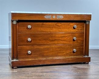 EMPIRE CHEST OF DRAWERS  |                                                          With white marble top, blind top drawer with brass Rossetti and other mounts over three full width drawers, flanked by half columns - l. 54 x w. 20 x h. 35 in.