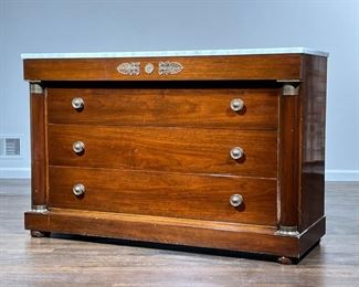 EMPIRE CHEST OF DRAWERS   |                                                     With white marble top, blind top drawer with brass Rossetti and other mounts over three full width drawers, flanked by half columns - l. 54 x w. 20 x h. 35 in.
